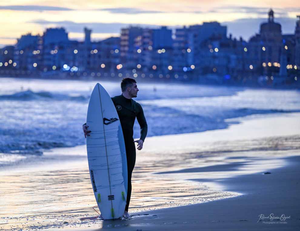 Surfeur avec sa planche sur le côté