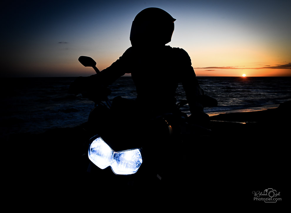 Photo motard sur sa moto en contre jour