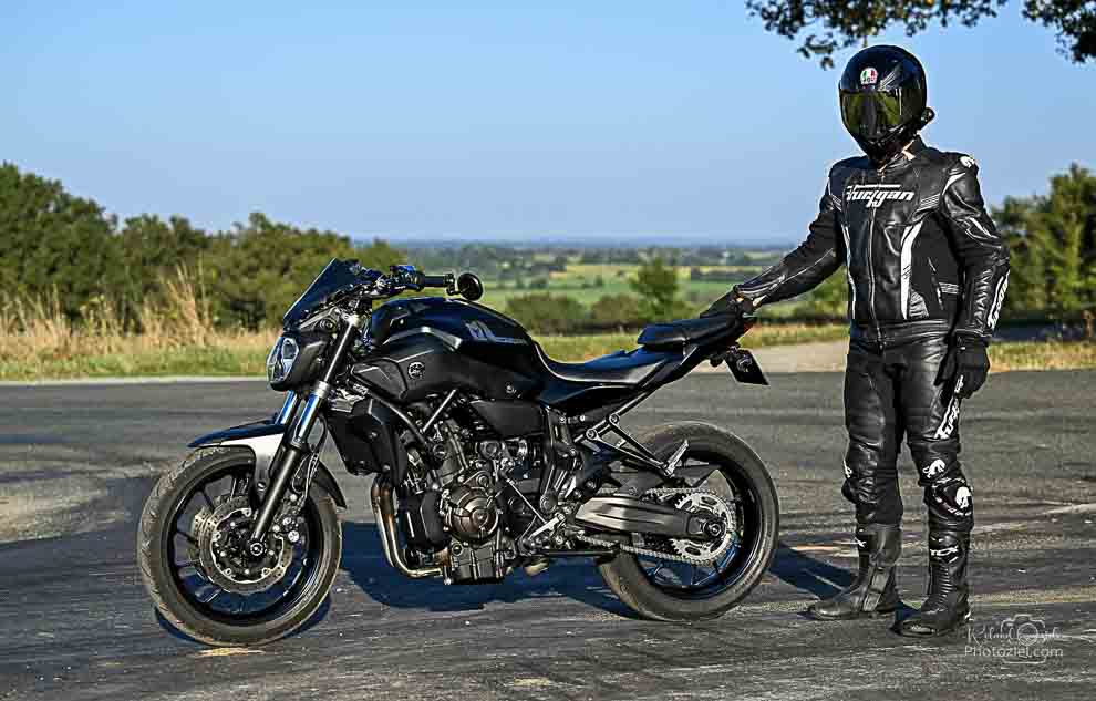 Le motard tient sa moto à bout de bras