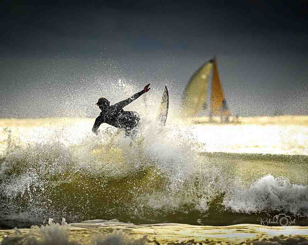 Photo d&apos;un surfeur avec un bateau en arrière plan